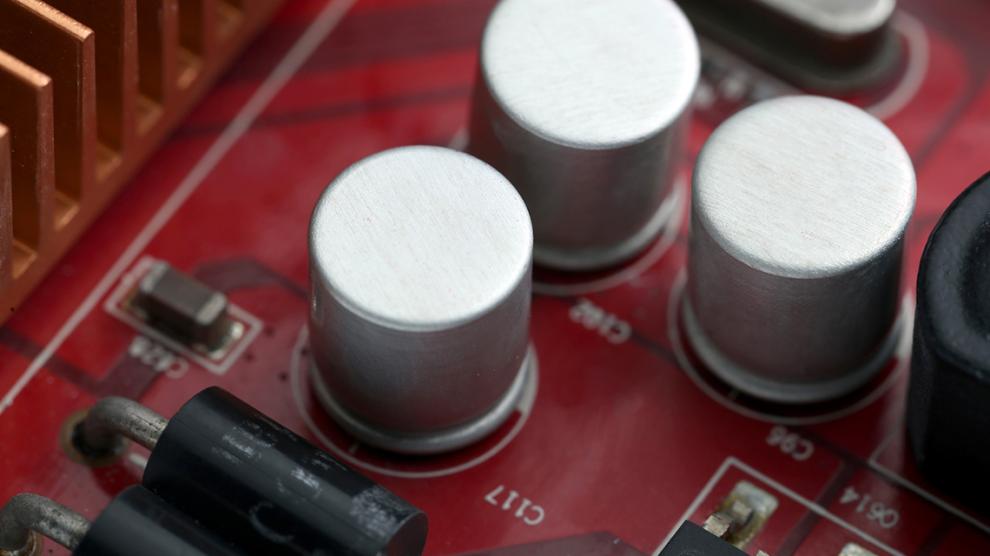Close-up of capacitors and components on a red electronic motherboard